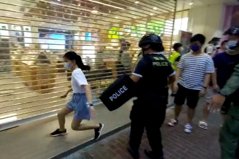 Hong Kong riot police on Sunday rounded up a group of people in Mong Kok district, including a 12-year-old girl (above) who tried to flee but was pushed to the ground and pinned down by officers (below).