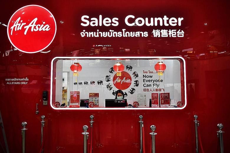 An AirAsia employee manning an empty sales counter at U-Tapao Airport in Rayong, Thailand, in February. The Malaysian budget carrier, which last month posted its largest quarterly loss on record, resumed domestic operations in late April, but its lon