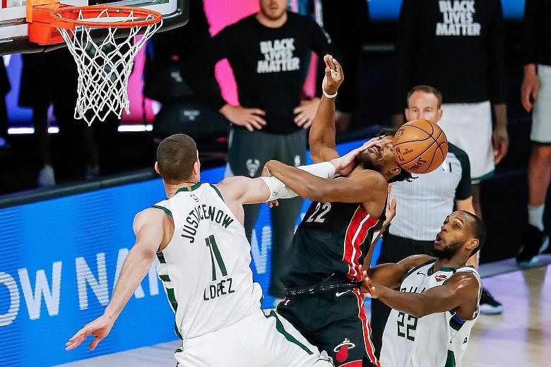 Milwaukee's Brook Lopez resorting to fouling Jimmy Butler to stop the Miami star from an easy bucket. Butler was more successful on other drives to the basket as the Heat dumped the Bucks out of the play-offs.