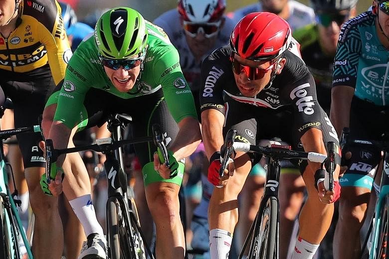 Caleb Ewan of Australia (in red helmet) and Sam Bennett of Ireland sprinting towards the line at the Tour de France in Poitiers yesterday. Ewan won the 11th stage, a 167.5km ride from Chatelaillon-Plage. Slovak Peter Sagan was second and Bennett thir