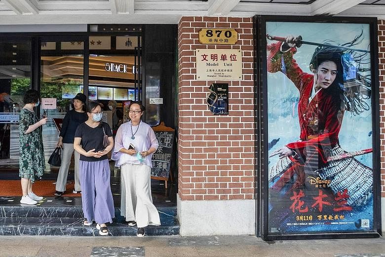 People exiting a cinema advertising the movie Mulan in Shanghai yesterday. In China, where the movie is set to open tomorrow, early viewers have also panned the film on movie review site Douban, rating it 4.7 points out of 10, accusing producers of O