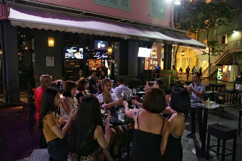 Patrons at Le Noir in Clarke Quay on March 25, before the circuit breaker. The bar is among seven F&B outlets in popular nightspots that were fined $1,000 each for failing to comply with safe distancing rules over the weekend. It will also be suspend