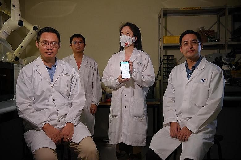 The team behind the smart mask system - (from far left) Professor Chen Xiaodong, research fellows Liang Pan and Wang Cong, and Professor Loh Xian Jun. Ms Wang is wearing the smart mask, which allows the wearer's real-time health data to be transmitte