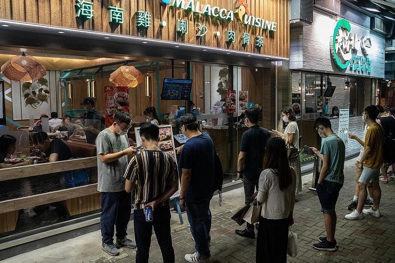 Customers waiting to enter a restaurant in the Sai Wan Ho district of Hong Kong last month. Singapore's Consulate-General in Hong Kong said that given the strong business and social ties between the two cities, the resumption of cross-border travel w