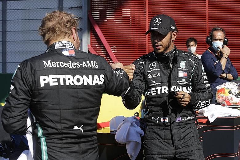 Mercedes drivers Lewis Hamilton and Valtteri Bottas fist-bumping each other after securing another one-two on the podium.