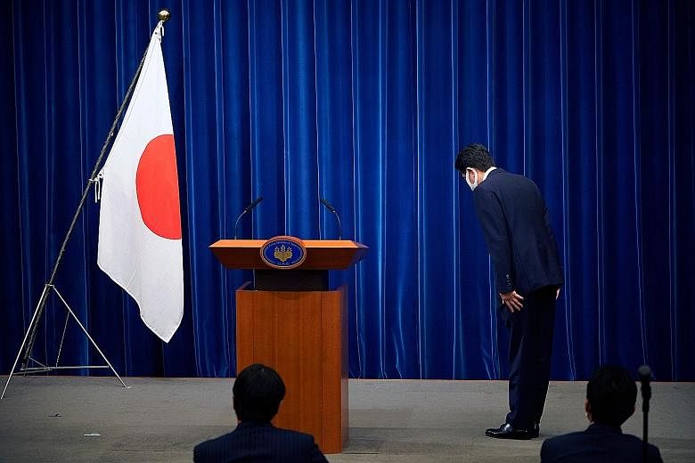 Prime Minister Shinzo Abe bowing to the Japanese flag in the prime minister's official residence in Tokyo on Aug 28 before he announced that he would resign over health problems.