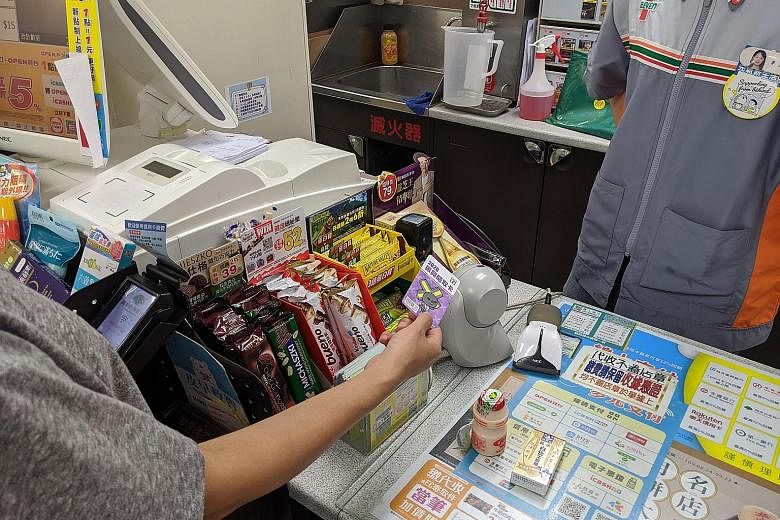 A customer paying at 7-Eleven with a voucher value card. Under a government programme to invigorate the economy hit by the pandemic, Taiwanese pay NT$1,000 (S$47) each for NT$3,000 vouchers that can be used to buy various goods and services.
