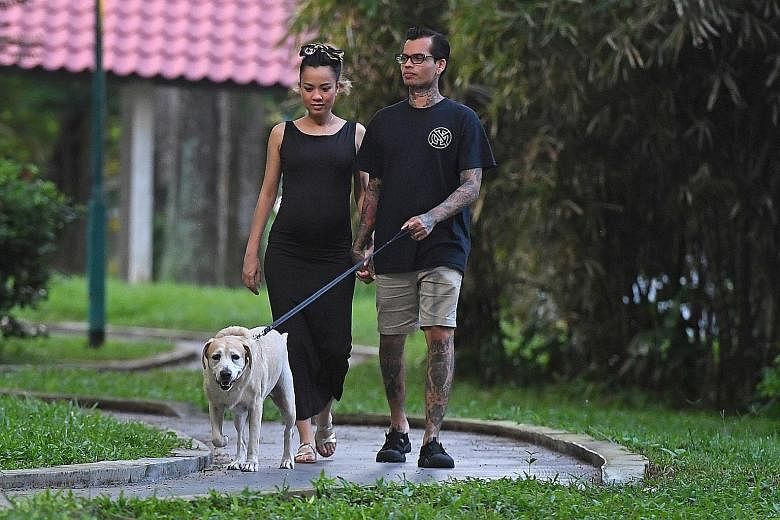 Ms Jillian Lim and her husband Kenneth Christopher Meals with their nine-year-old labrador retriever Blitz, whom they adopted last year under Project Adore's K-9 scheme for retired sniffer dogs.