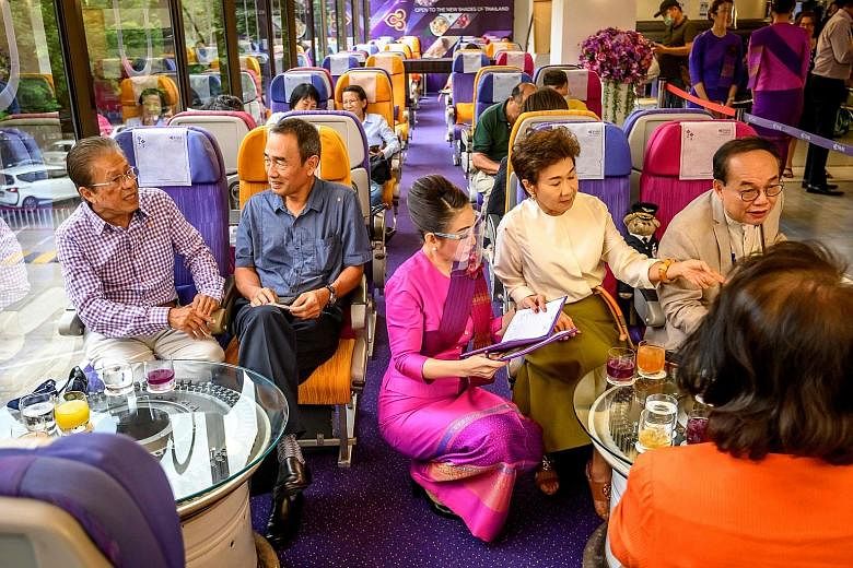 Above: A Thai Airways flight attendant serving customers at a pop-up cafe at the airline's headquarters in Bangkok. Below: Diners at a cafe built in a retired Airbus A-330 airplane, outside the coastal city of Pattaya in Chonburi province.