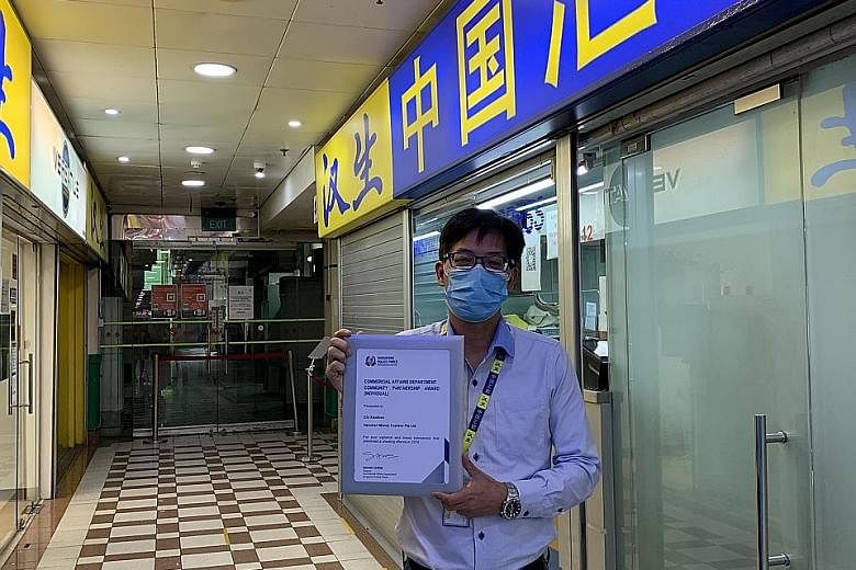 Mr Chi Xiao Biao, a counter staff member at Hanshan Money Express Remittance, with his Community Partnership Award. He was one of 108 individuals and 15 organisations lauded by the Commercial Affairs Department for their contributions to detecting an