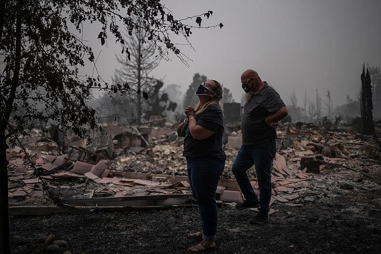 A couple on the site of their fire-gutted home in Talent, Oregon, last Saturday. A blitz of wildfires across Oregon, California and Washington states has destroyed thousands of homes and a half dozen small towns this summer, killing more than two doz