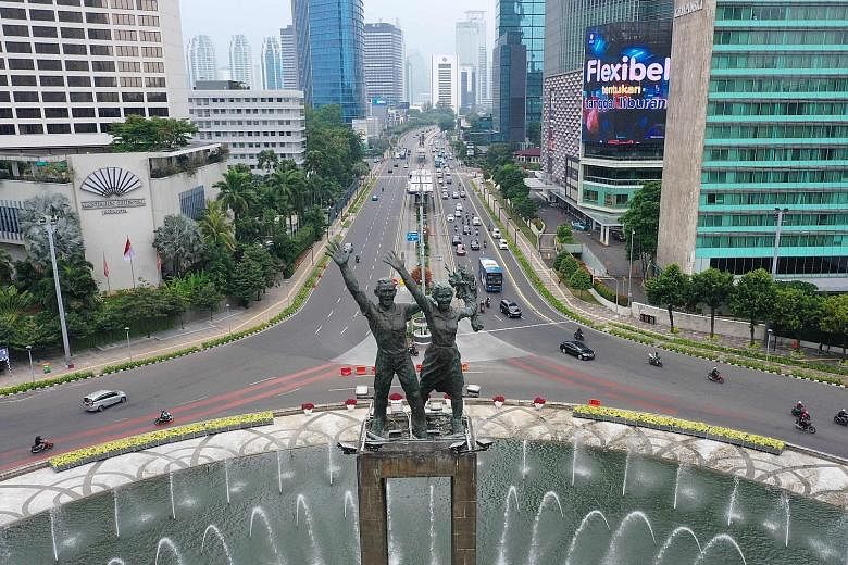 Lighter-than-usual traffic at Jakarta's Hotel Indonesia roundabout as the city went into a less restrictive lockdown yesterday. Unlike the large-scale lockdown in April, companies in non-essential sectors can continue to operate on condition that onl