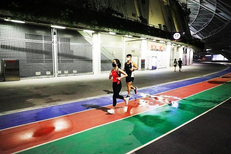 A couple running at the 100PLUS Promenade which reopened to the public on Monday. Several facilities at the Sports Hub are now open after the end of the temporary housing arrangement for migrant workers during the coronavirus pandemic. PHOTO: LIANHE 