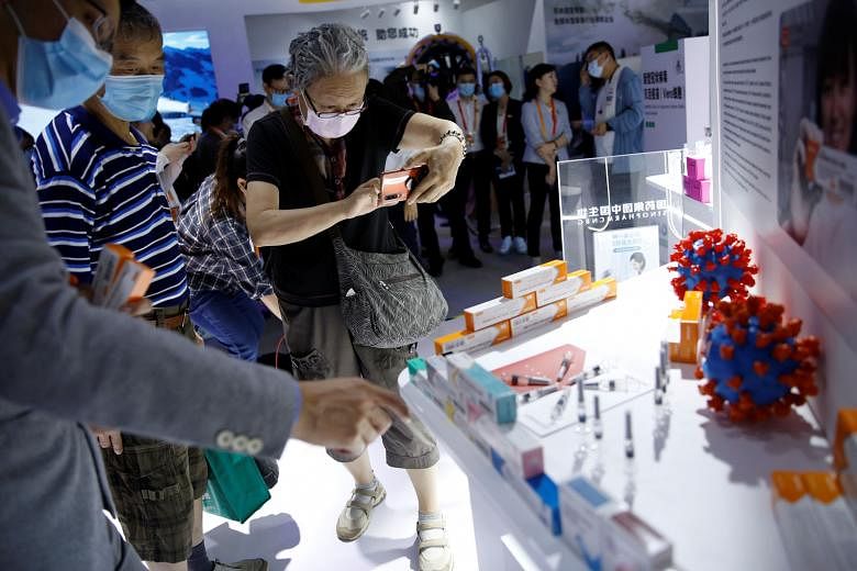 Visitors at a booth displaying a coronavirus vaccine candidate from Sinovac Biotech at the 2020 China International Fair for Trade in Services on Sept 5 in Beijing. PHOTO: REUTERS