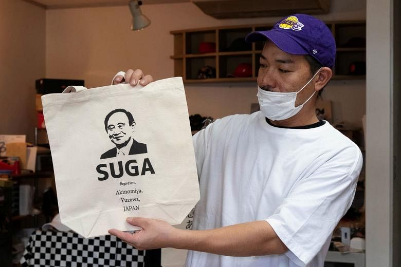 Designer Ippei Fujita, who runs a shop named Marble in Yuzawa, with a tote bag featuring Mr Suga's image. Mr Suga won a ruling party election on Monday to succeed Mr Shinzo Abe as prime minister of Japan.