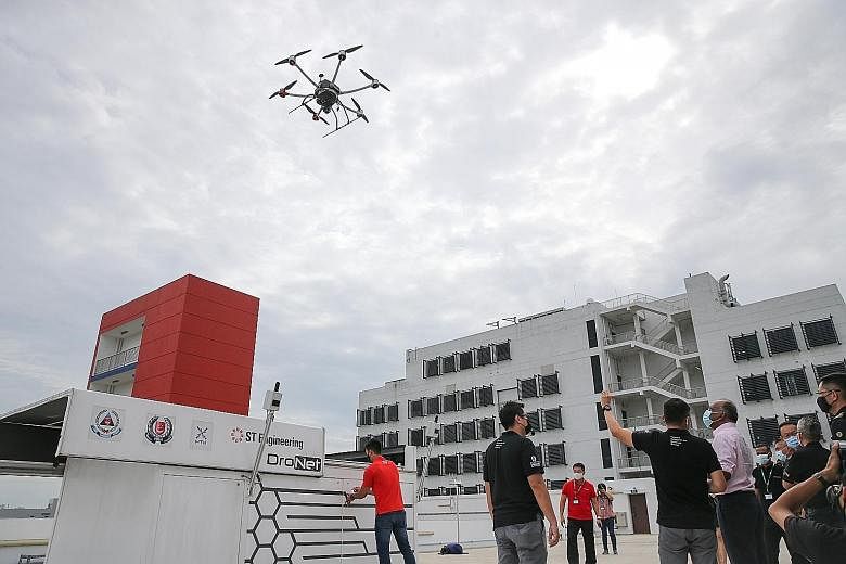 Home Affairs and Law Minister K. Shanmugam watching the drone take off during a flight demonstration at Tuas View Fire Station yesterday. The machine was developed by the Home Team Science and Technology Agency and ST Engineering Aerospace. ST PHOTO: