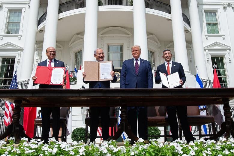 US President Donald Trump looking on as (from left) Bahrain Foreign Minister Abdullatif Al-Zayani, Israeli Prime Minister Benjamin Netanyahu and United Arab Emirates Foreign Minister Abdullah bin Zayed Al-Nahyan hold up documents after the signing of