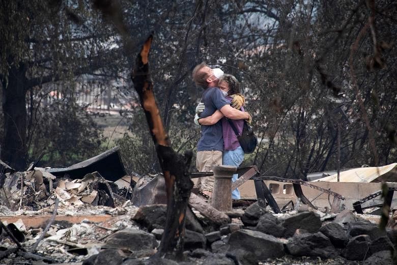 Ms Dee Perez comforting Mr Michael Reynolds at the ruins of his home that was destroyed in the Almeda Fire in Talent, Oregon on Tuesday.