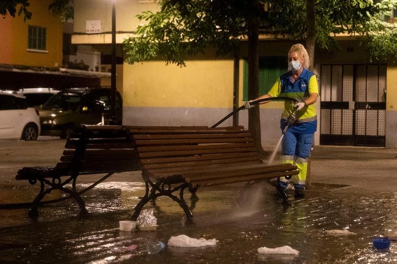 A street in Palma de Mallorca, capital of Spain's Balearic Islands, being disinfected earlier this week. The central government is set to unveil new restrictions to curb the virus. PHOTO: AGENCE FRANCE-PRESSE The queue at a coronavirus testing statio