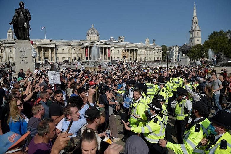 Police holding back protesters at an anti-vax rally in central London yesterday. The UK's official number of new positive cases shot up by nearly 1,000 on Friday to 4,322, the highest since May 8.
