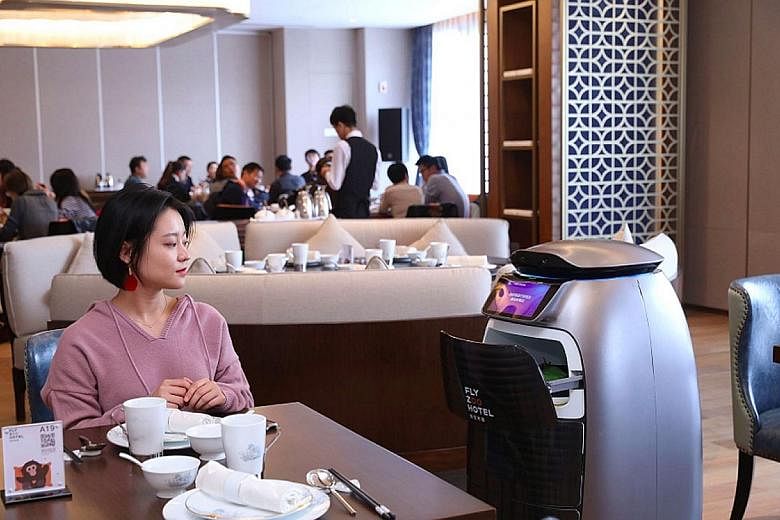 A diner being served by a robot in a restaurant at the FlyZoo Hotel in Hangzhou, China.