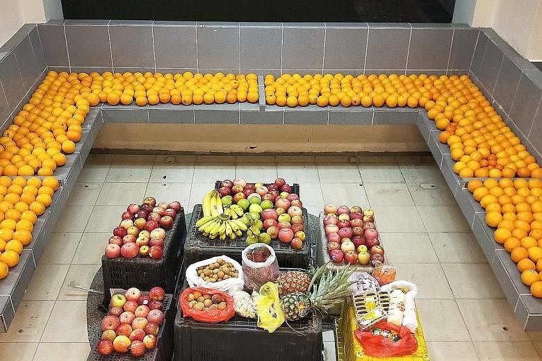 For avid "freegan" Daniel Tay and his friends, fruits make up the bulk of what they collect as they fan out across Housing Board blocks in Ang Mo Kio and Bishan for fresh offerings during the Hungry Ghost Festival.