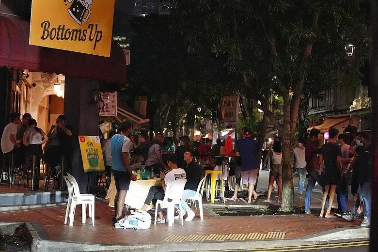 Patrons outside Bottoms Up on Friday. The Sunday Times understands that the bar in Telok Ayer Street was issued a fine earlier this month for not complying with safe management measures. With the Government clamping down on food and beverage outlets 