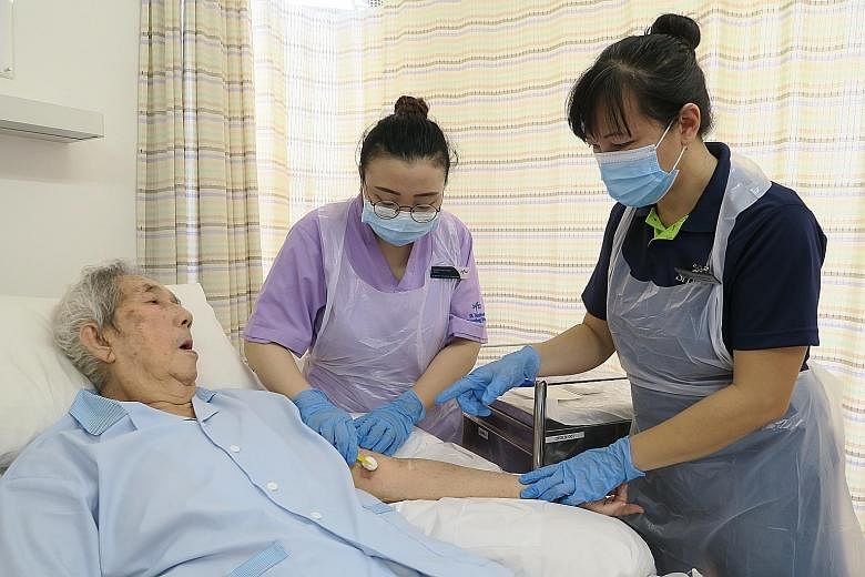 Assistant nurse clinician Caroline Tan (at right) from St Luke's Hospital training staff nurse Naqiyah Yusuf at St Andrew's Nursing Home (Taman Jurong) in wound care. St Luke's will use the Lew Foundation grant to extend its wound care expertise to t
