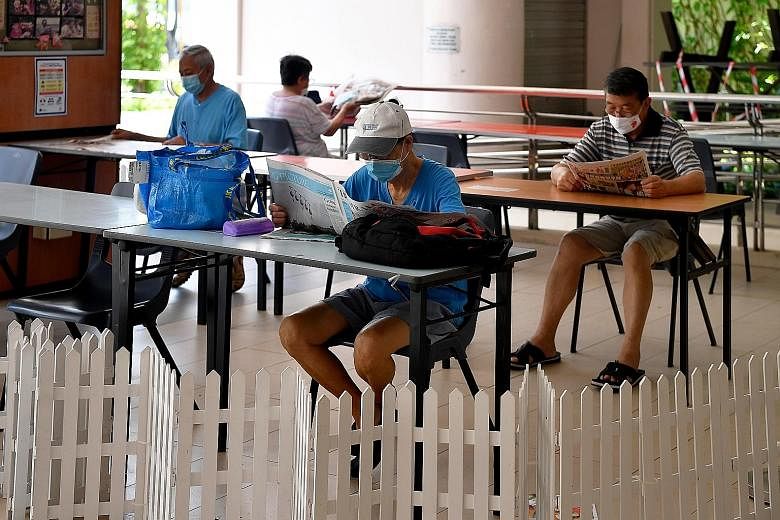 People reading newspapers at the Pasir Ris East Community Building last Friday. While there were no new cases in the community, Singapore recorded nine new imported cases.