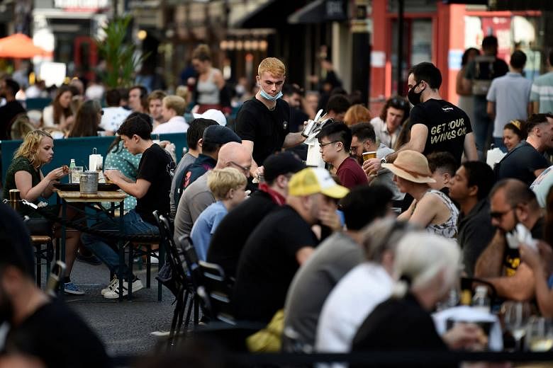 Left: Diners at a restaurant in London. Medical experts say that with winter approaching, the Covid-19 problem would haunt Britain for another six months at least. The country has the highest official Covid-19 death toll in Europe - and the fifth-lar