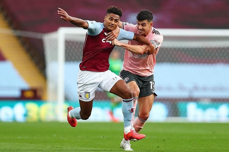 Sheffield United's John Egan (right) tugging on the shirt of Aston Villa striker Ollie Watkins. The defender was sent off for his troubles, leaving the 10-man Blades to lose their second Premier League game of the season 1-0. PHOTO: REUTERS