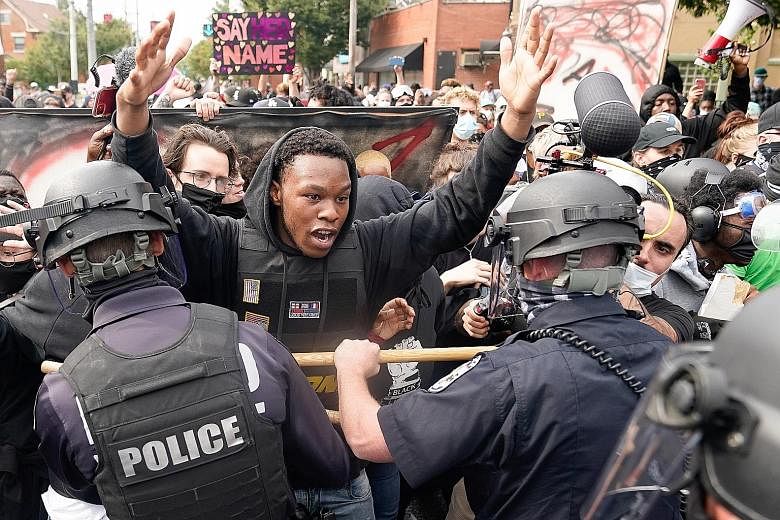 A protester clashing with the police after a grand jury ruling on the killing of Ms Breonna Taylor in Louisville, Kentucky, on Wednesday.