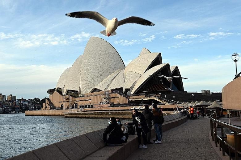 Visitors near Sydney Opera House in Australia. The government's Covid-19 curbs have taken a steep toll on the economy, with tough restrictions forcing many small businesses to shut.