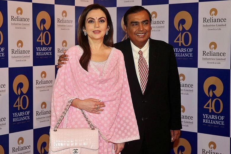 India's Mr Mukesh Ambani, seen here with his wife Nita, is Asia's richest person, followed by Mr Zhong Shanshan. Alibaba co-founder Jack Ma, seen here speaking at the company's tech conference in China's Hangzhou city in 2018, may soon regain his spo
