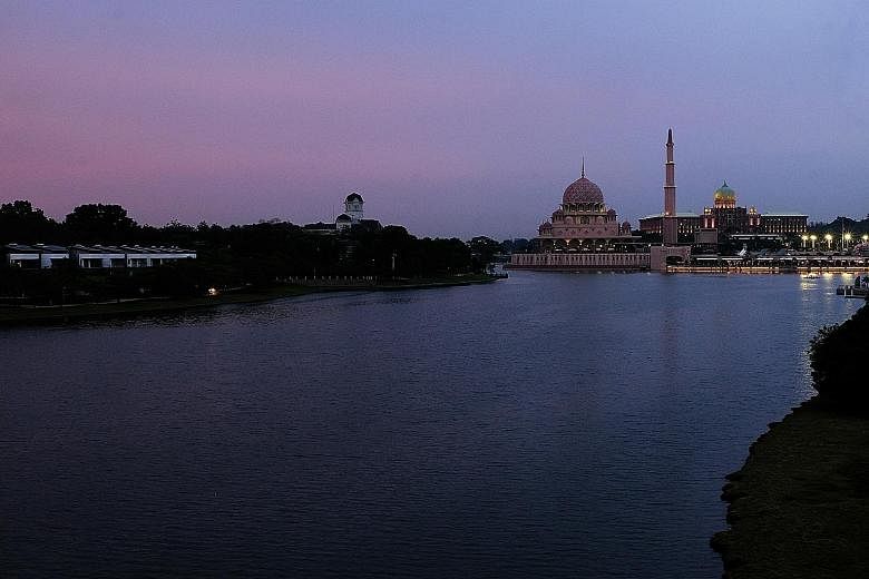 The placid waters of a lake in Putrajaya, Malaysia's administrative capital, belie the turbulence that has rocked the political scene. Prime Minister Muhyiddin Yassin (left), who has a wafer-thin majority in Parliament, has to stave off a power play 