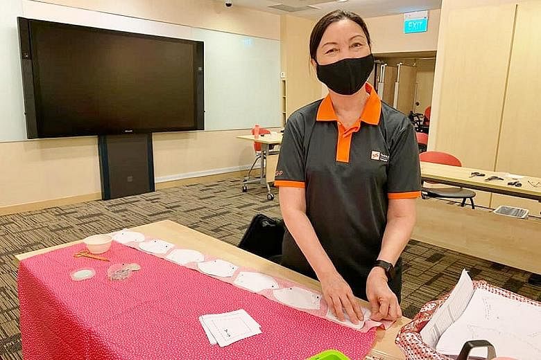 Nurse clinician Ou Lee Hua (above) and senior nurse manager in nursing administration Daisy Tng (left) from SingHealth Polyclinics working on the masks. They were among SHP nurses who assembled and sewed masks to raise money for needy patients.