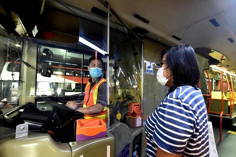 Above: Having a shield around a bus driver's seat is one of the measures being studied to protect drivers from the coronavirus and abuse by commuters. Right: Mr Muhammad Mu'tasim Kassim and Mr Clement Tan Zhi Hao, two of three men who stopped an assa