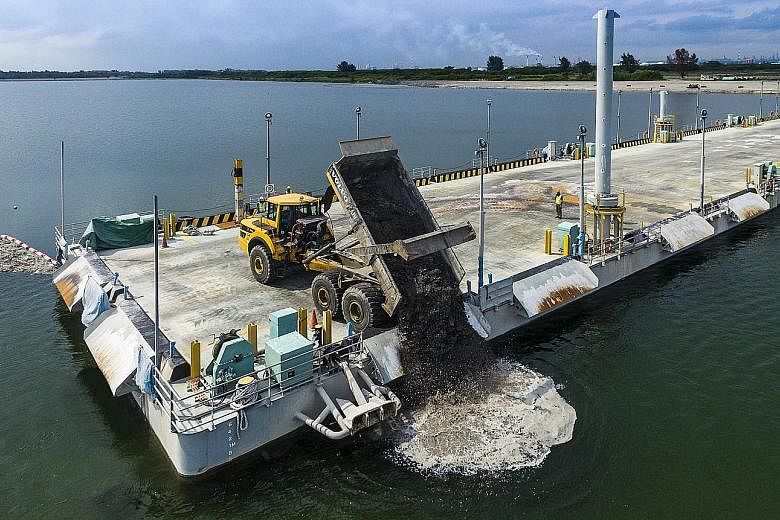 A dump truck discharging incineration ash from the Floating Platform at Semakau Landfill. A tugboat and barge berthed at Semakau Landfill.
