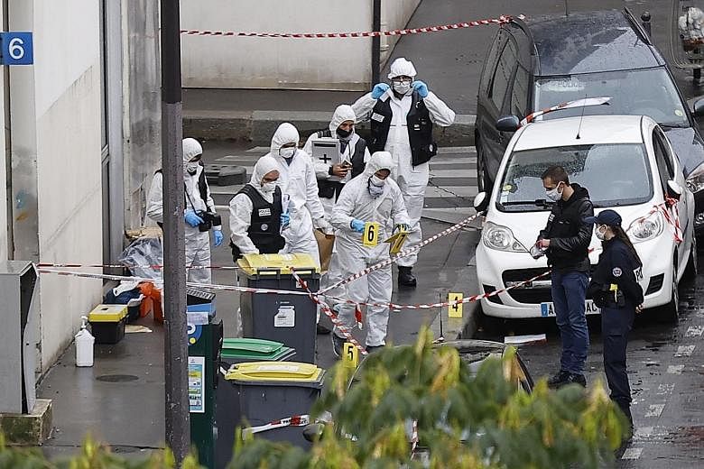 French forensic police investigators at the site of the knife attack near the former offices of Charlie Hebdo in Paris on Friday. Seven people are being held in connection with the attack. They include the "main perpetrator", who was arrested not far