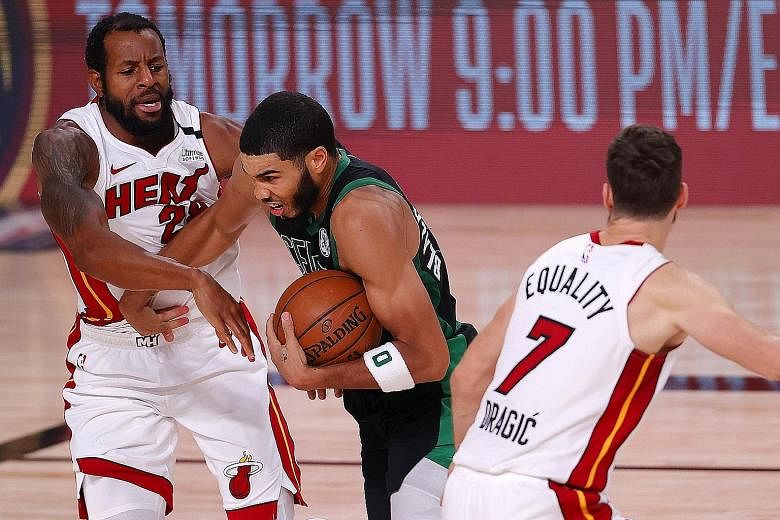 Boston Celtics' Jayson Tatum driving past two Miami Heat players during Game 5 of the Eastern Conference Finals. PHOTO: AGENCE FRANCE-PRESSE
