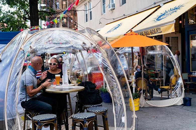 Customers sitting in bubble tents outside a cafe in Manhattan, New York City, last Wednesday. Top US infectious disease expert Anthony Fauci said in an interview there is a fear that "things could actually get worse", as the country surpassed the gri