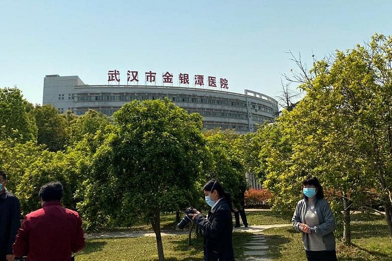 Above: Jinyintan Hospital in the Chinese city of Wuhan was one of the first to start treating Covid-19 patients. Right: ST's China correspondent Elizabeth Law in Wuhan. In the background is Huanan Seafood Wholesale Market, where the coronavirus was b