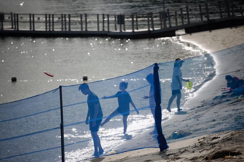 People playing with frisbees behind a barrier separating different sections of Siloso Beach on Sentosa last Wednesday. On why many people are planning to use their tourism vouchers on attractions and staycations, Dr Michael Chiam, a senior tourism le