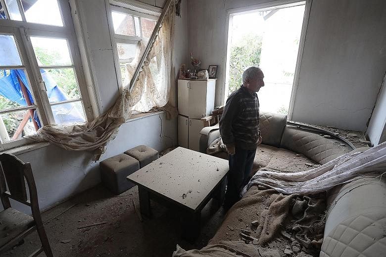 An Armenian surveying the damage to his house in Nagorno-Karabakh yesterday, after recent shelling by Azeri forces. A video grab allegedly showing an Azeri artillery strike towards the positions of Armenian separatists in Nagorno-Karabakh. The fierce