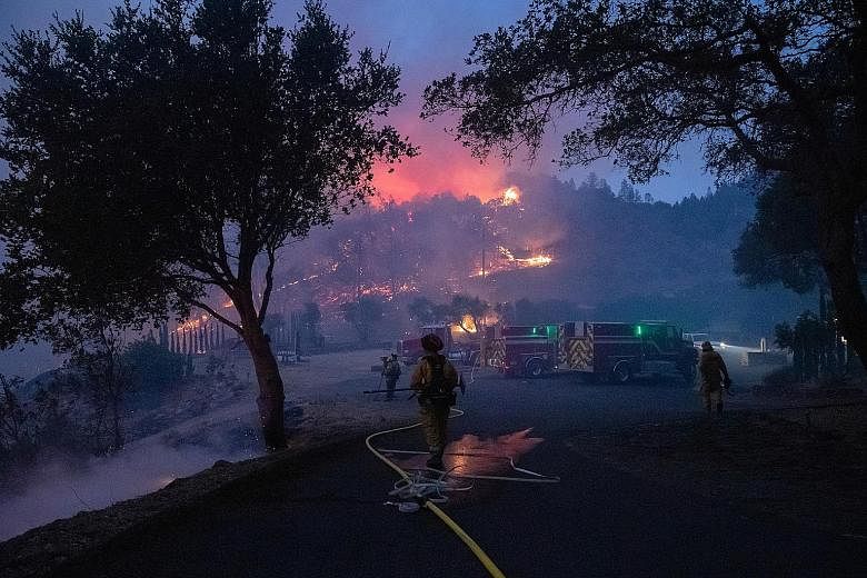 Firefighters battling the Glass Fire as it encroached upon a vineyard in Deer Park, California, on Sunday. The blaze erupted midway through the traditional grape-harvesting period in the Napa Valley, world renowned as one of California's premier wine