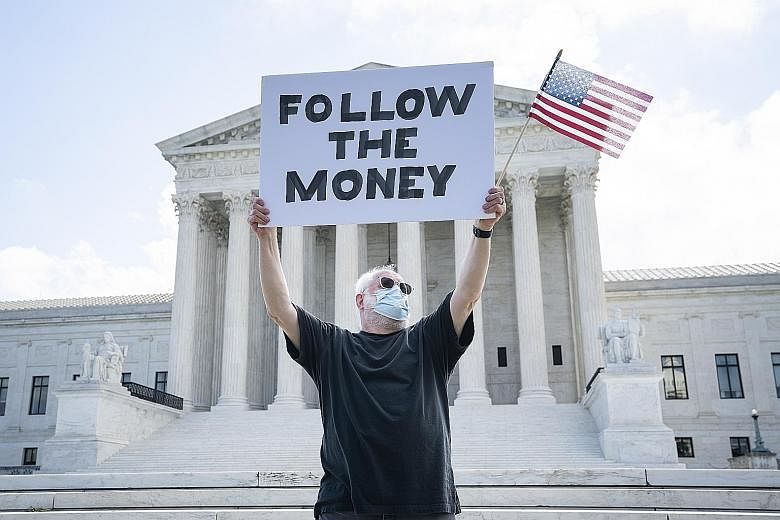 A protester outside the Supreme Court in July as it ruled on two cases seeking to acquire President Donald Trump's financial records, including his tax returns. President Donald Trump speaking during a news conference at the White House on Sunday. He