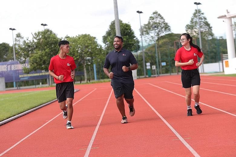 Physical education lecturer Mark Daniel running with Mikhail Raiyan, a second-year Nitec student in electrical engineering, power and control, and Ng Li Yan, in her first year in the Nitec travel and tourism services course. ST PHOTO: TIMOTHY DAVID