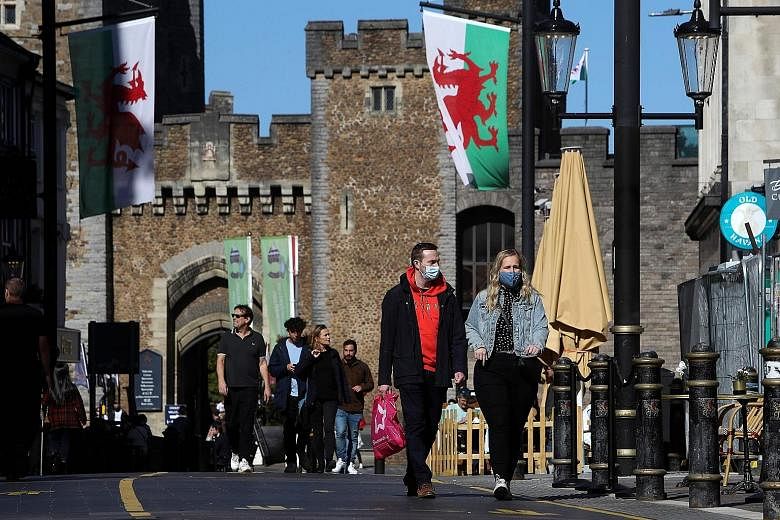 People walking in the city of Cardiff, in the south of Wales, on Sunday. A British newspaper reported that ministers were preparing to enforce a total social lockdown across much of northern England and potentially London.