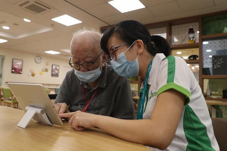 Right: Mr Lau Han Cheong, 86, assisted by occupational therapist Kuo Yen Chun, 35, using the My House of Memories app (above), which contains multimedia features and images of relatable everyday items from Singapore's yesteryear. The app is a result 