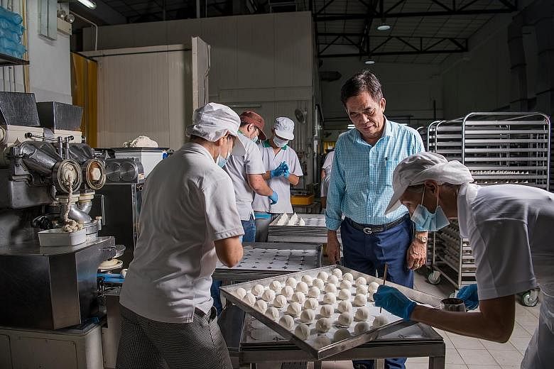 Mr Ang He Siong (in blue shirt) with workers making steamed vegan paste buns at Lim Kee's manufacturing facility in Woodlands. Lim Kee worked with Enterprise Singapore, which helped the firm build its vegan processing line and apply for vegan certifi